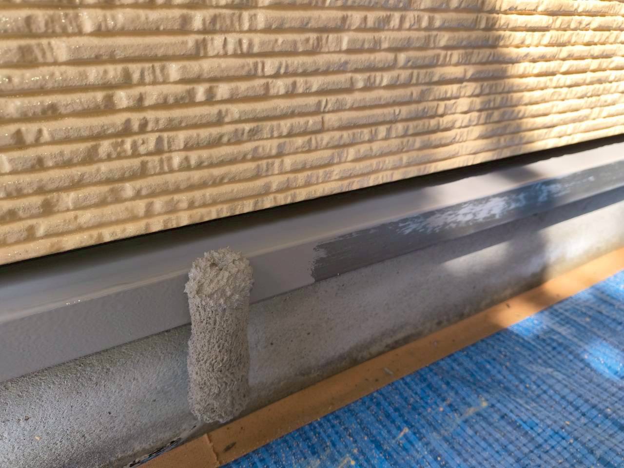 金属専用塗料で土台水切りを塗装中